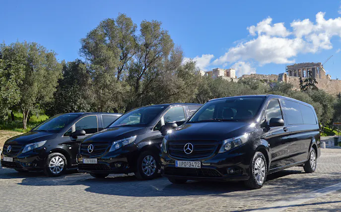 Minivans parked near the Acropolis in Athens for airport transfer service.