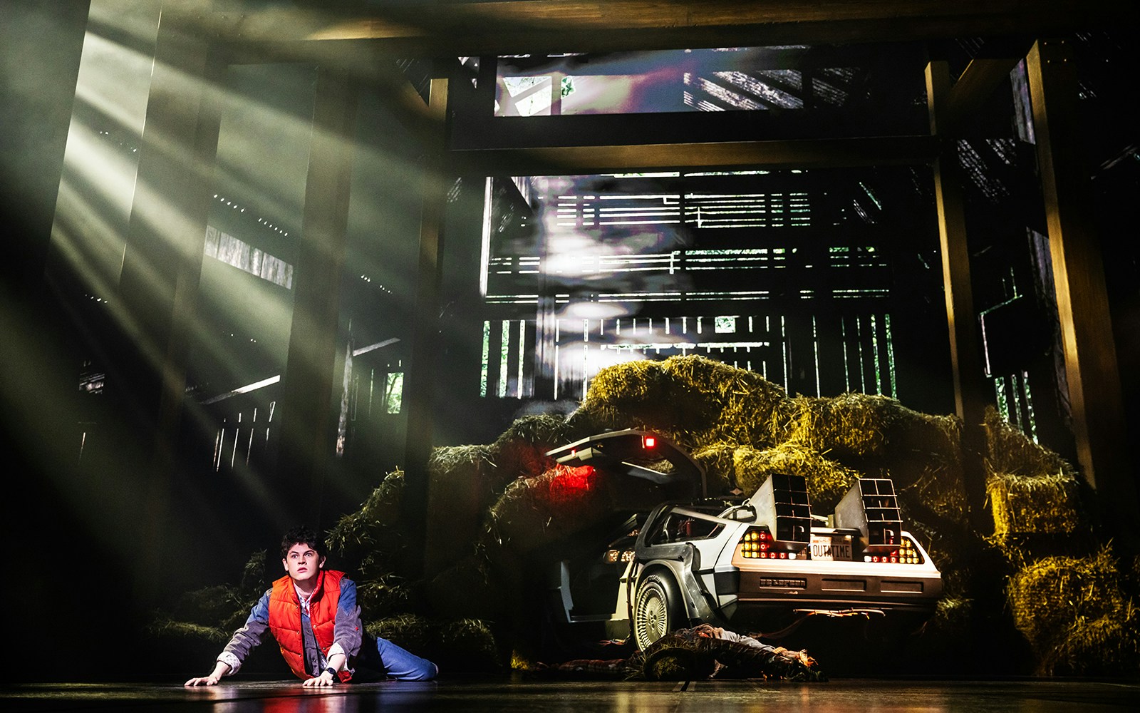 Stage scene from Back to the Future the Musical with DeLorean in a barn.