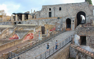 Visitors ascending a stone path at Pompeii ruins, Italy.