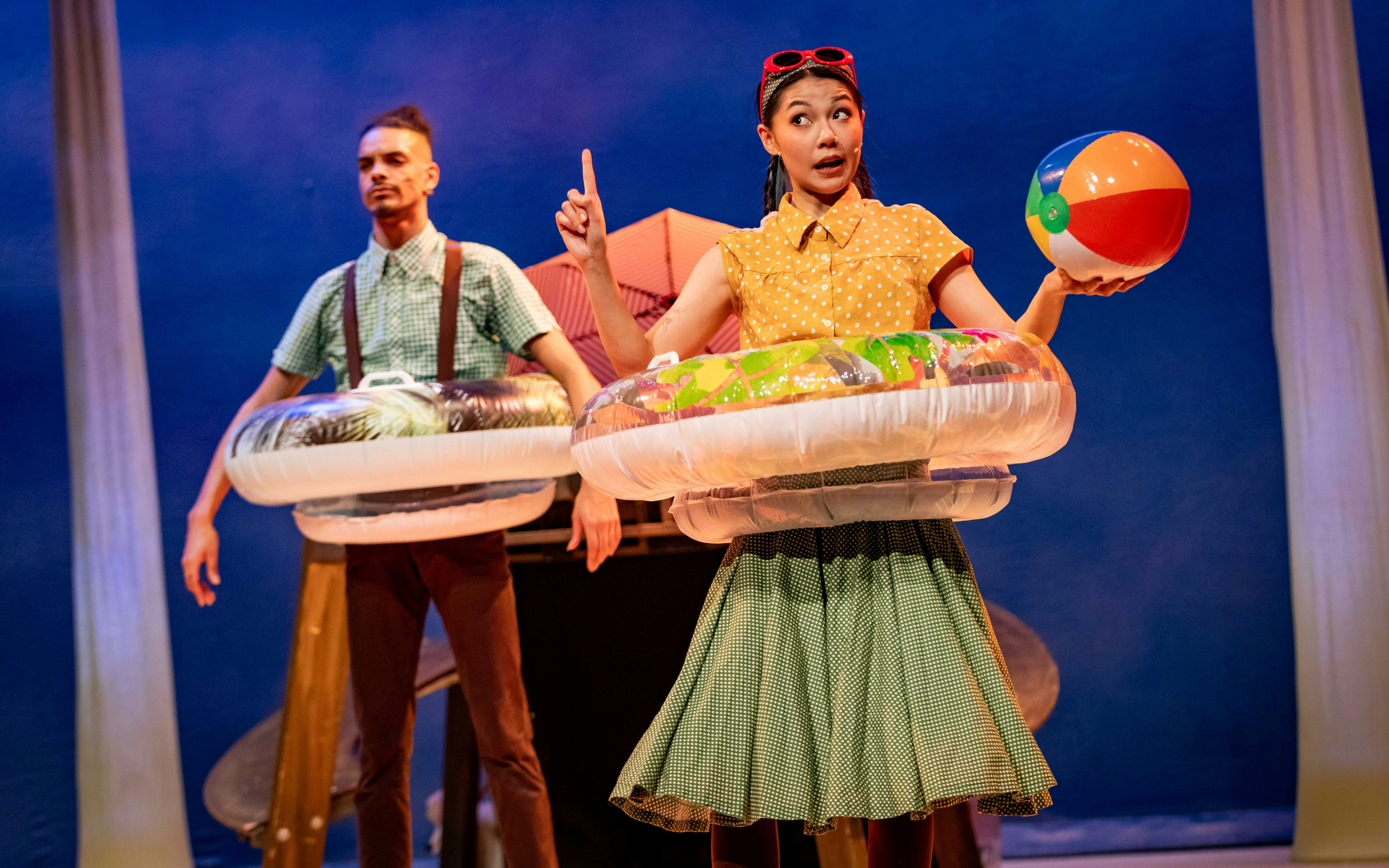 Stage performance of Stick Man in Westend with actors holding inflatable rings and a beach ball.