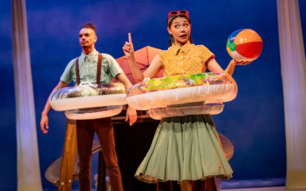 Stage performance of Stick Man in Westend with actors holding inflatable rings and a beach ball.