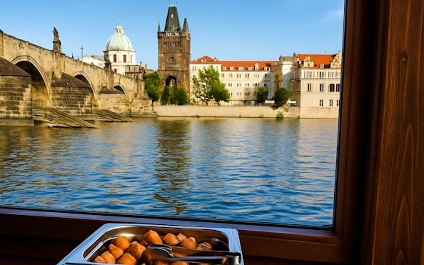 Buffet lunch with view of Charles Bridge during Prague river cruise.