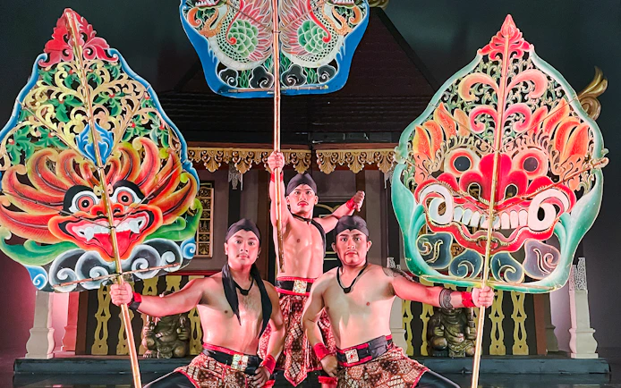Performers holding ornate shields during the Devdan Show in Bali, showcasing cultural artistry.