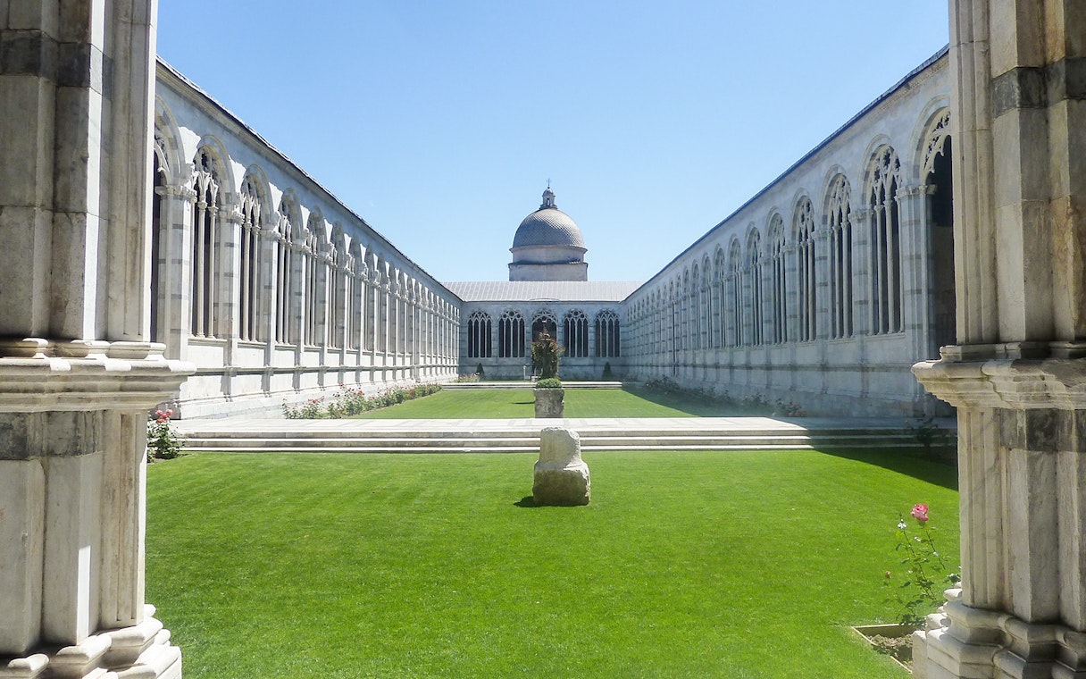 Pisa Baptistery and Cathedral courtyard with arches and central dome.