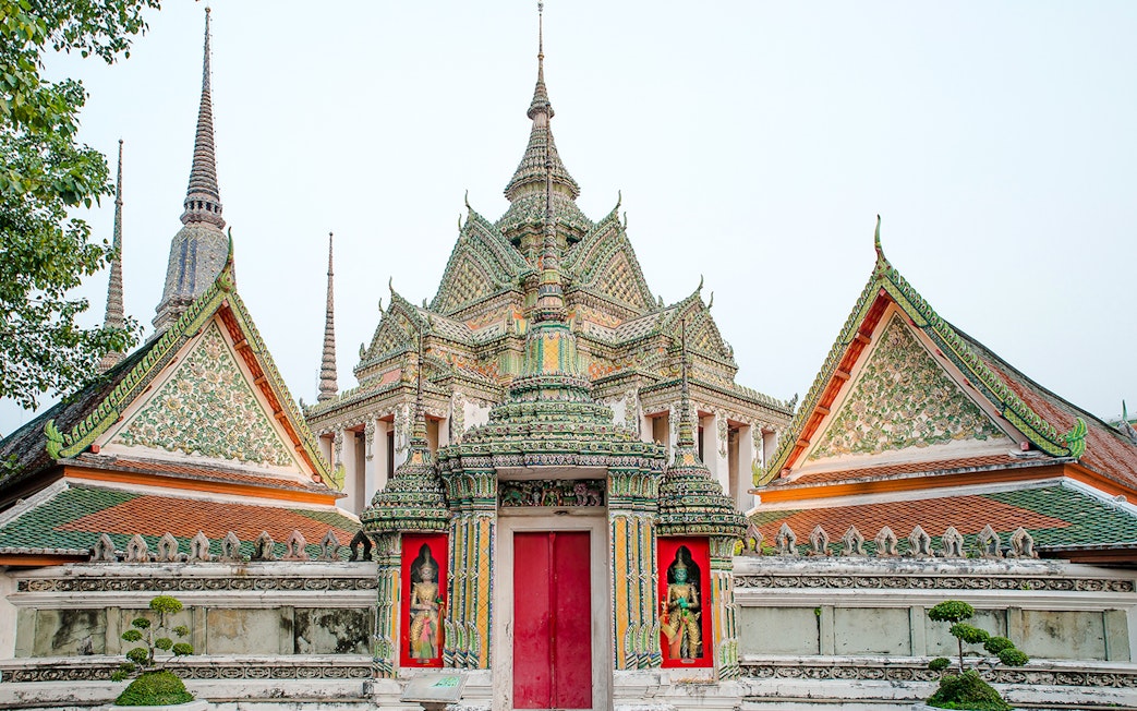 Wat Pho temple complex with ornate spires and intricate carvings, Bangkok, Thailand.