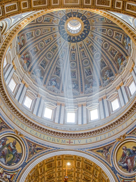 Interior view of St. Peter’s Basilica dome with intricate artwork, Vatican City.