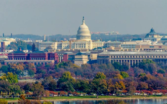 U.S. Capitol building in Washington DC surrounded by autumn trees.