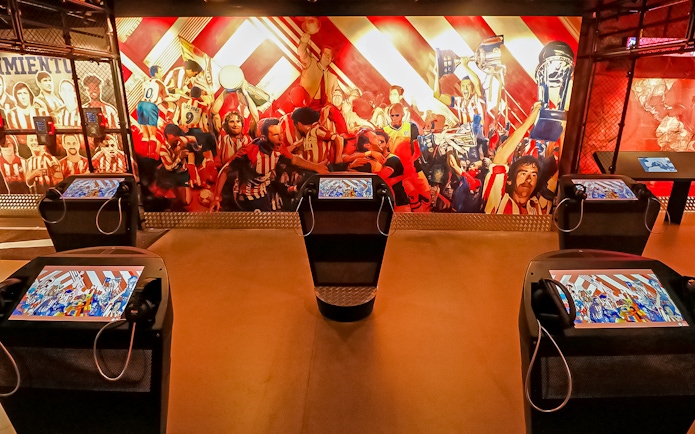 Interactive exhibit at Atletico de Madrid Stadium Museum with vibrant mural and digital displays.