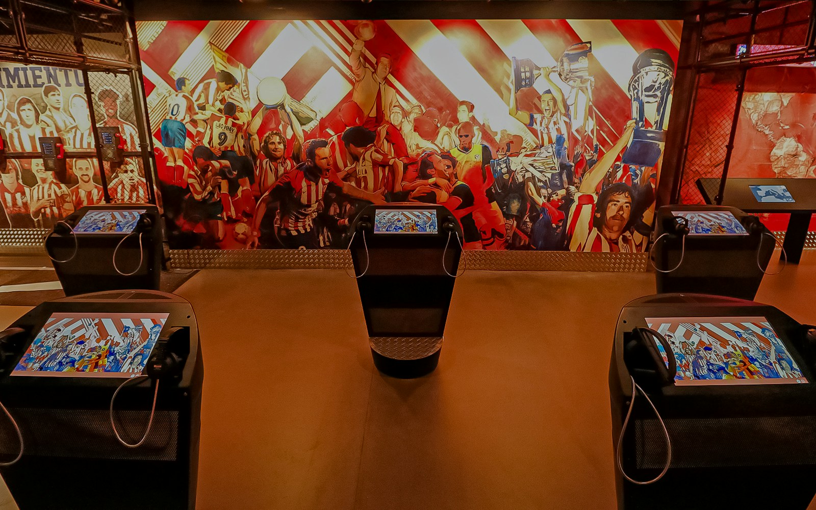 Interactive exhibit at Atletico de Madrid Stadium Museum with vibrant mural and digital displays.