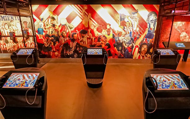 Interactive exhibit at Atletico de Madrid Stadium Museum with vibrant mural and digital displays.