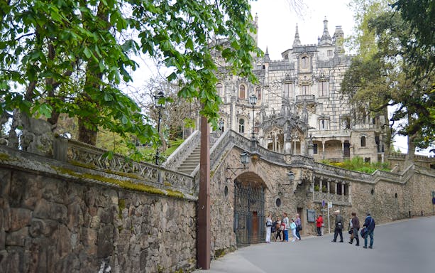 Quinta da Regaleira entrance with tourists in Sintra, Portugal.