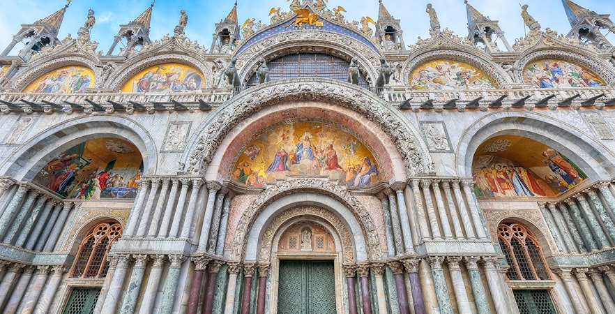 St Mark's Basilica entrance with ornate arches and detailed mosaics in Venice, Italy.