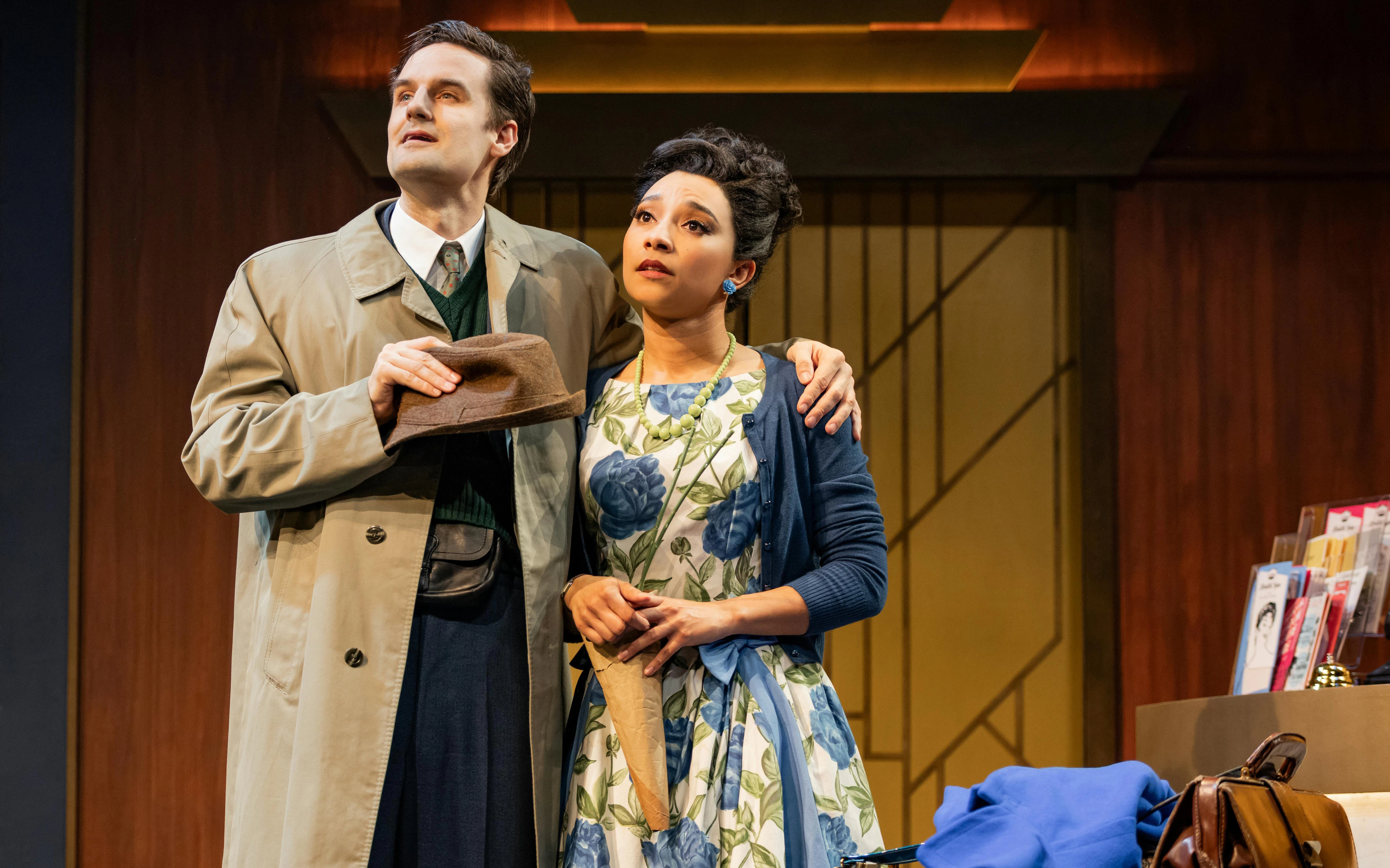 Actors performing in "The Comedy About Spies" on stage, with vintage attire and props.