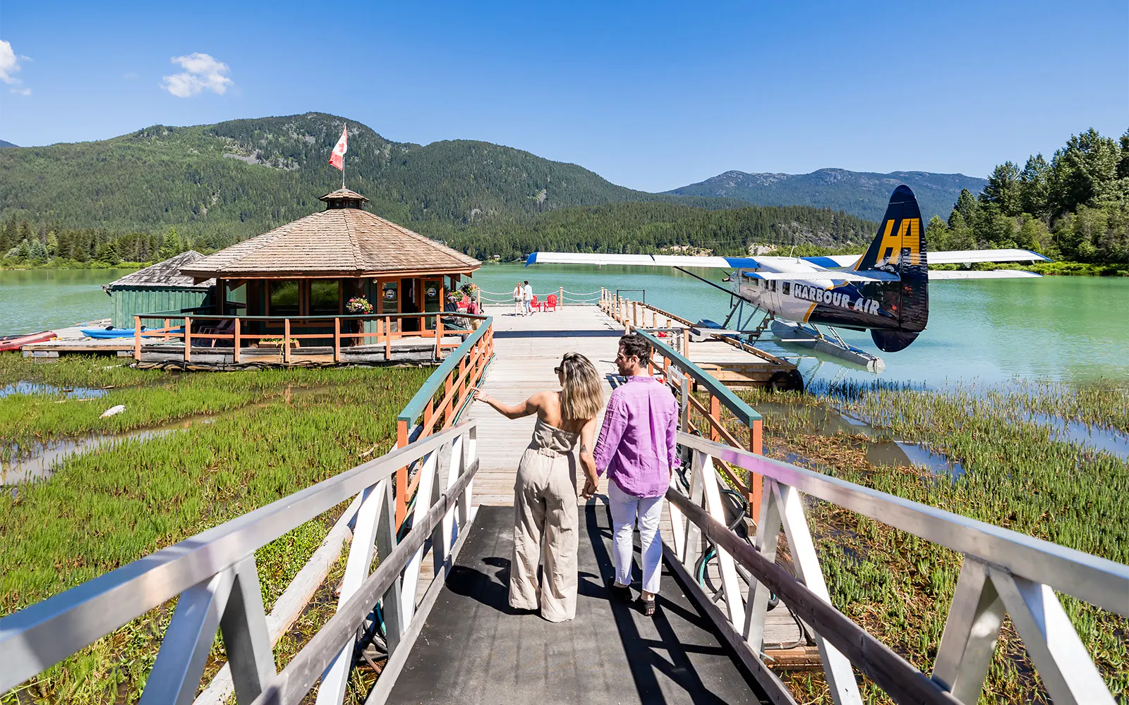 Couple walking towards seaplane dock for Whistler Glacier Seaplane Sightseeing Tour.