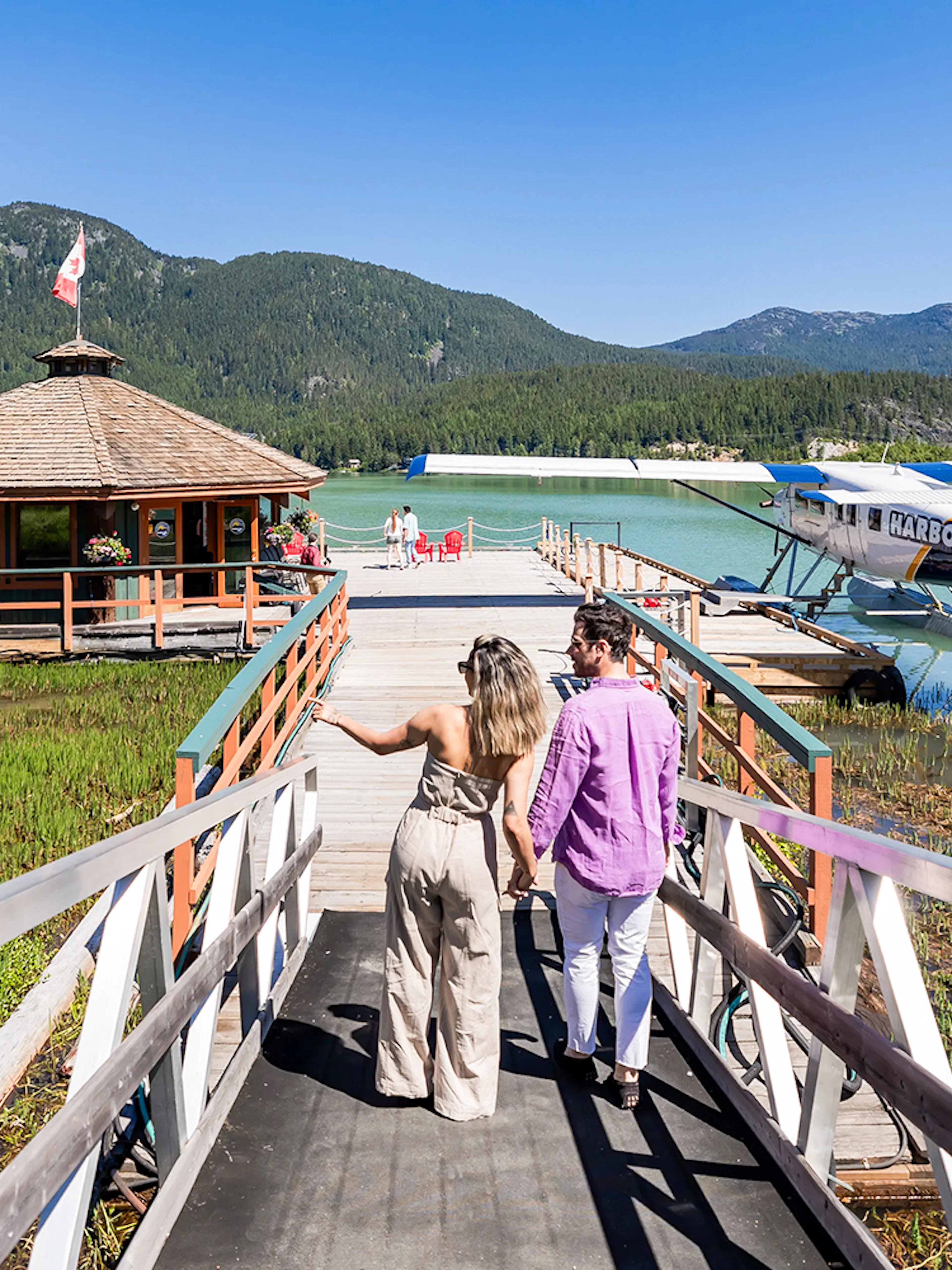 Couple walking towards seaplane dock for Whistler Glacier Seaplane Sightseeing Tour.