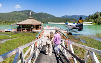 Couple walking towards seaplane dock for Whistler Glacier Seaplane Sightseeing Tour.
