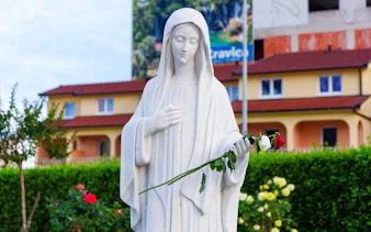 Statue of the Queen of Peace holding a rose near Saint James Church, Medjugorje.