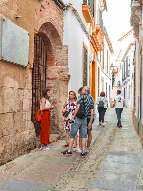 Tourists exploring a narrow street in Cordoba's Jewish Quarter.