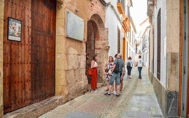 Tourists exploring a narrow street in Cordoba's Jewish Quarter.