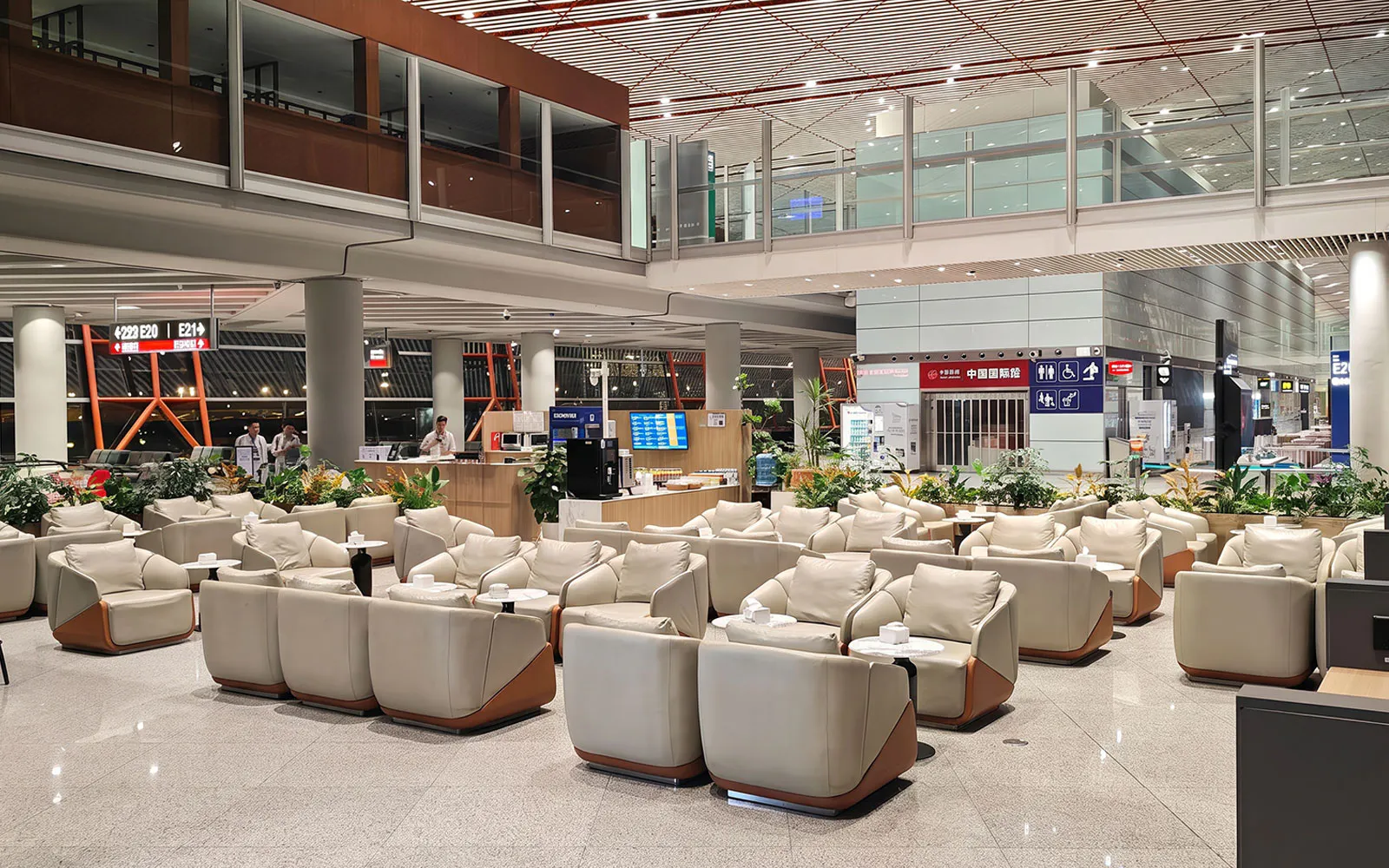 Seating area in Terminal 3 at Beijing Capital Airport with lounge chairs and information displays.