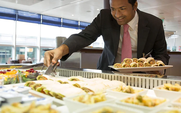 Man serving food at Aspire ONE Lounge buffet, Zurich Airport, Airside Centre, T1.