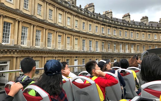 Open-top bus tour passing the Royal Crescent in Bath, England.