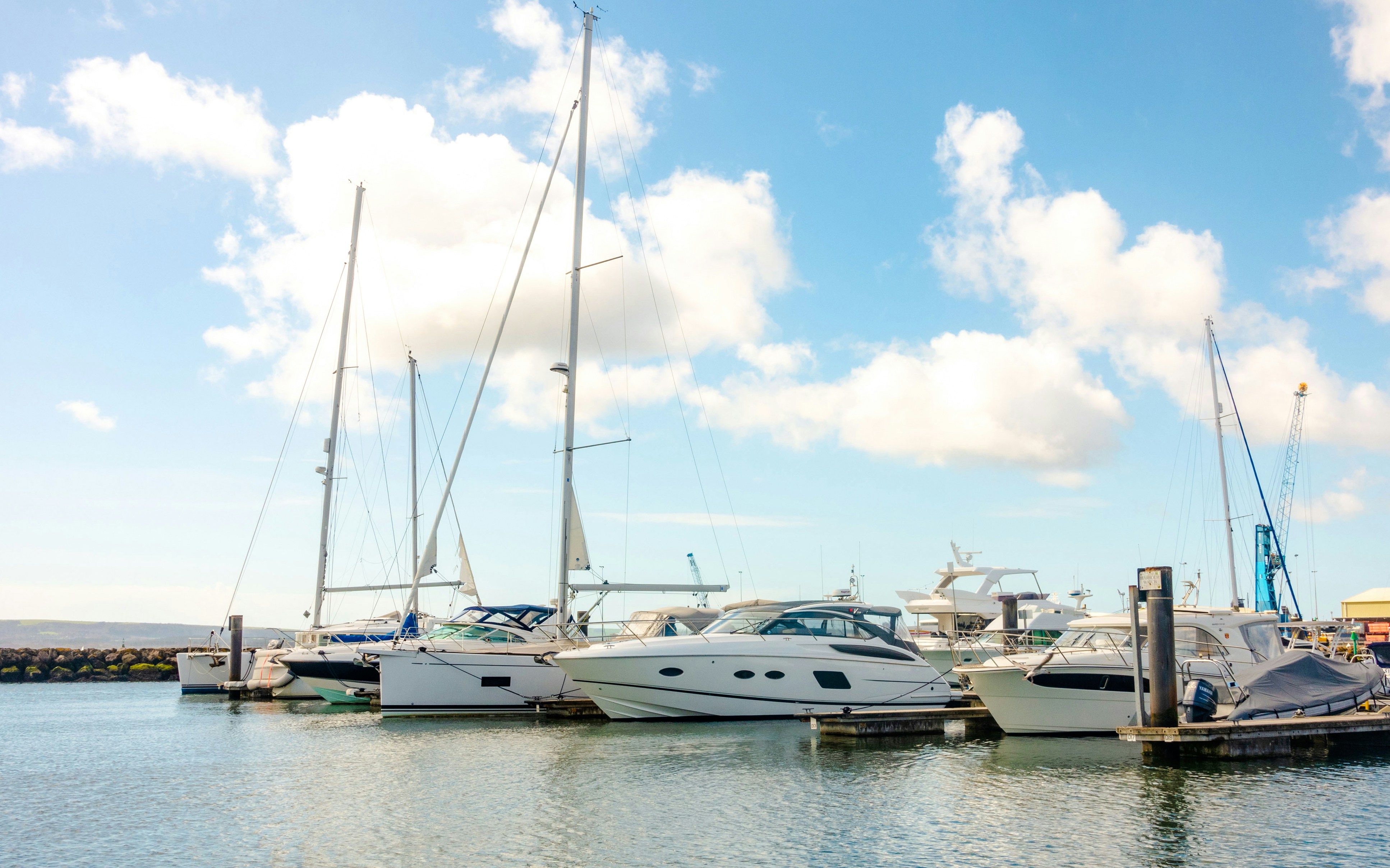 Boats docked at Poole Harbour in Bournemouth, Dorset under a clear sky.