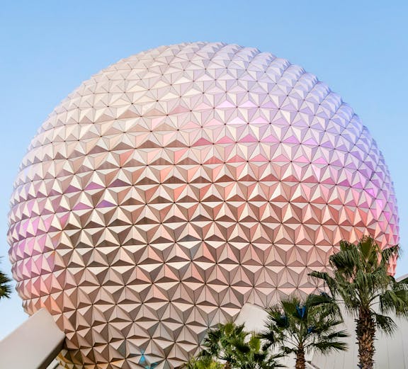 Spaceship Earth at EPCOT Center, Walt Disney Resort Orlando, with palm trees in foreground.