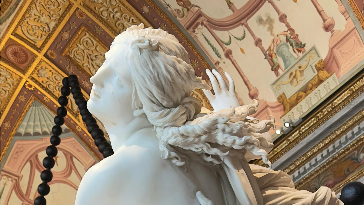 Bernini's "The Rape of Proserpina" sculpture detail in ornate gallery setting.
