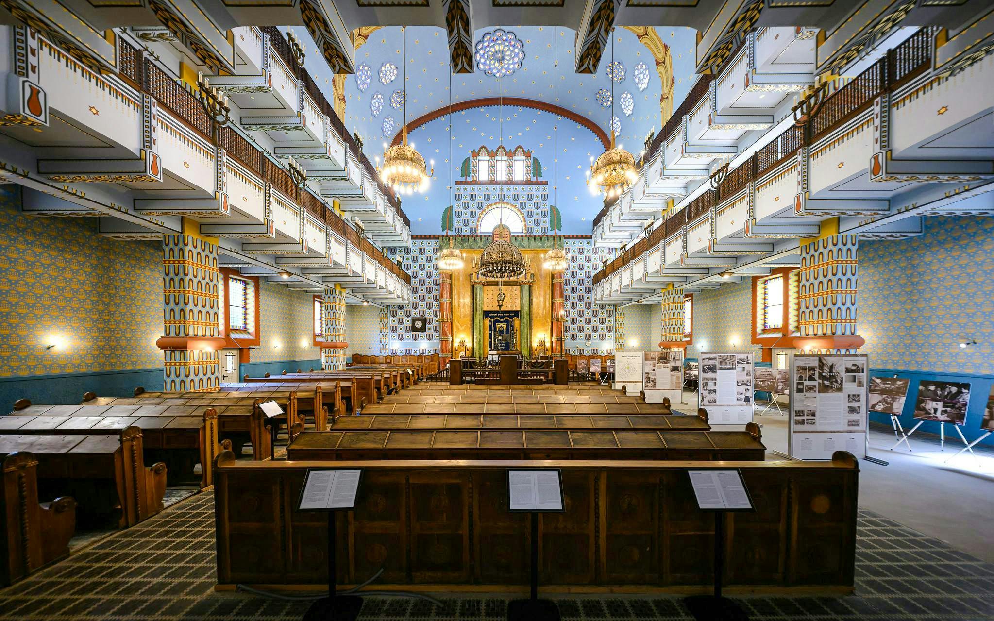 Interior of Kazinczy Synagogue in Budapest, featuring ornate balconies and chandeliers.