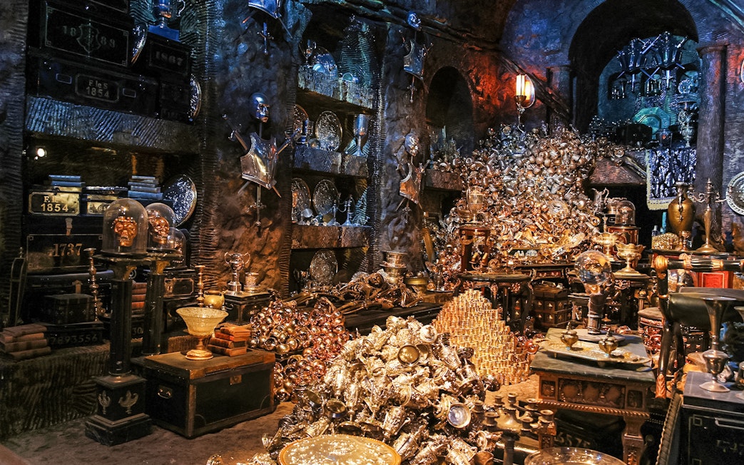 Treasure-filled room at Harry Potter London tour exhibit with goblets and armor.
