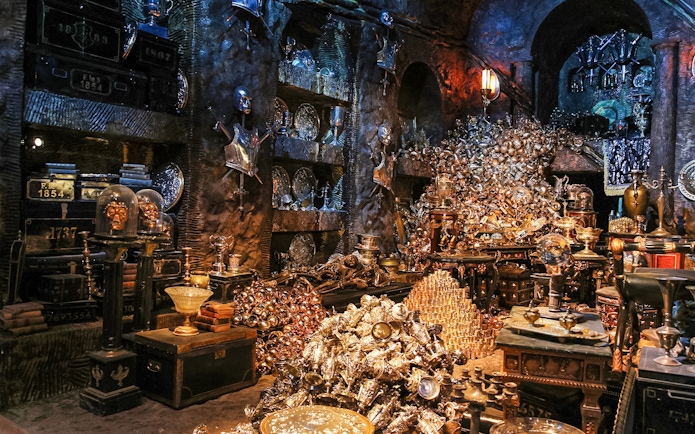 Treasure-filled room at Harry Potter London tour exhibit with goblets and armor.