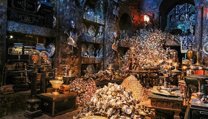 Treasure-filled room at Harry Potter London tour exhibit with goblets and armor.