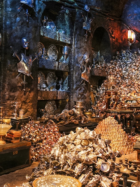 Treasure-filled room at Harry Potter London tour exhibit with goblets and armor.