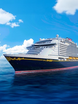 Disney cruise ship sailing on open sea under clear blue sky.