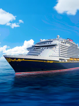 Disney cruise ship sailing on open sea under clear blue sky.