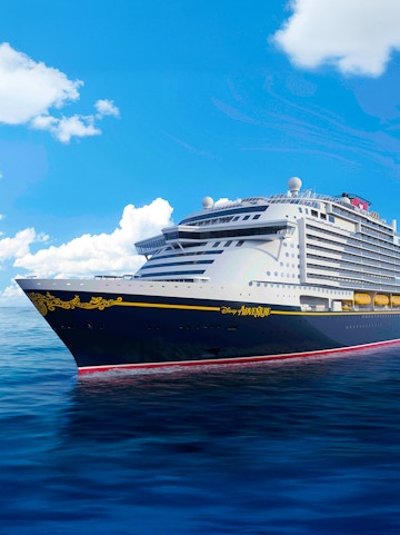 Disney cruise ship sailing on open sea under clear blue sky.