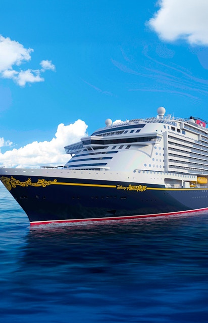Disney cruise ship sailing on open sea under clear blue sky.