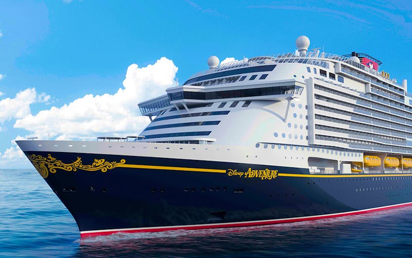 Disney cruise ship sailing on open sea under clear blue sky.