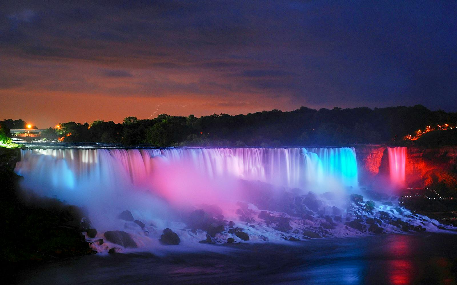Niagara Falls illuminated with colorful lights during an evening tour, USA.