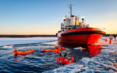 Icebreaker cruise with people floating in icy water during Icebreaker Cruise & Ice Floating Experience.
