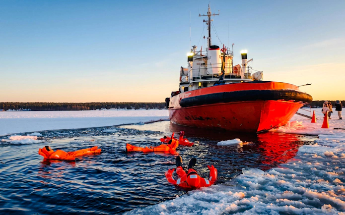 Icebreaker cruise with people floating in icy water during Icebreaker Cruise & Ice Floating Experience.
