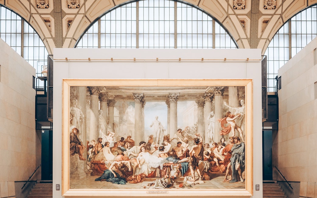 Painting of classical scene with figures and columns inside Orsay Museum, Paris.