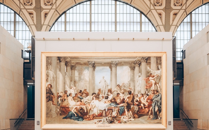 Painting of classical scene with figures and columns inside Orsay Museum, Paris.