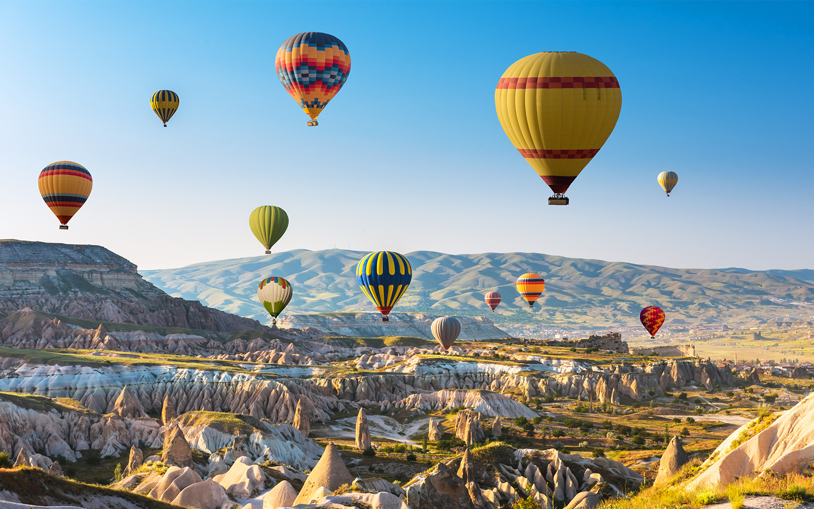 Hot air balloon over scenic landscape near Blue Planet Aquarium, showcasing aerial views.