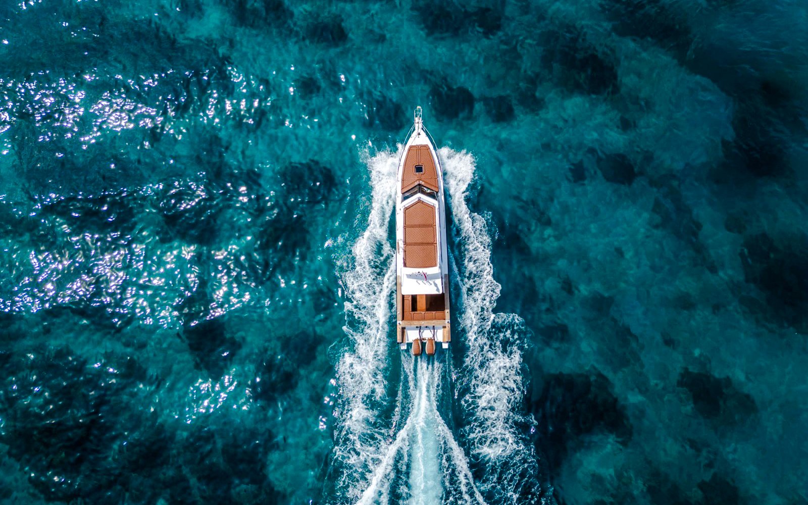 Boat cruising on clear blue waters near West Nusa Penida Island.