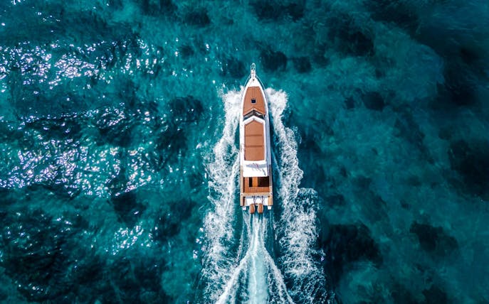 Boat cruising on clear blue waters near West Nusa Penida Island.