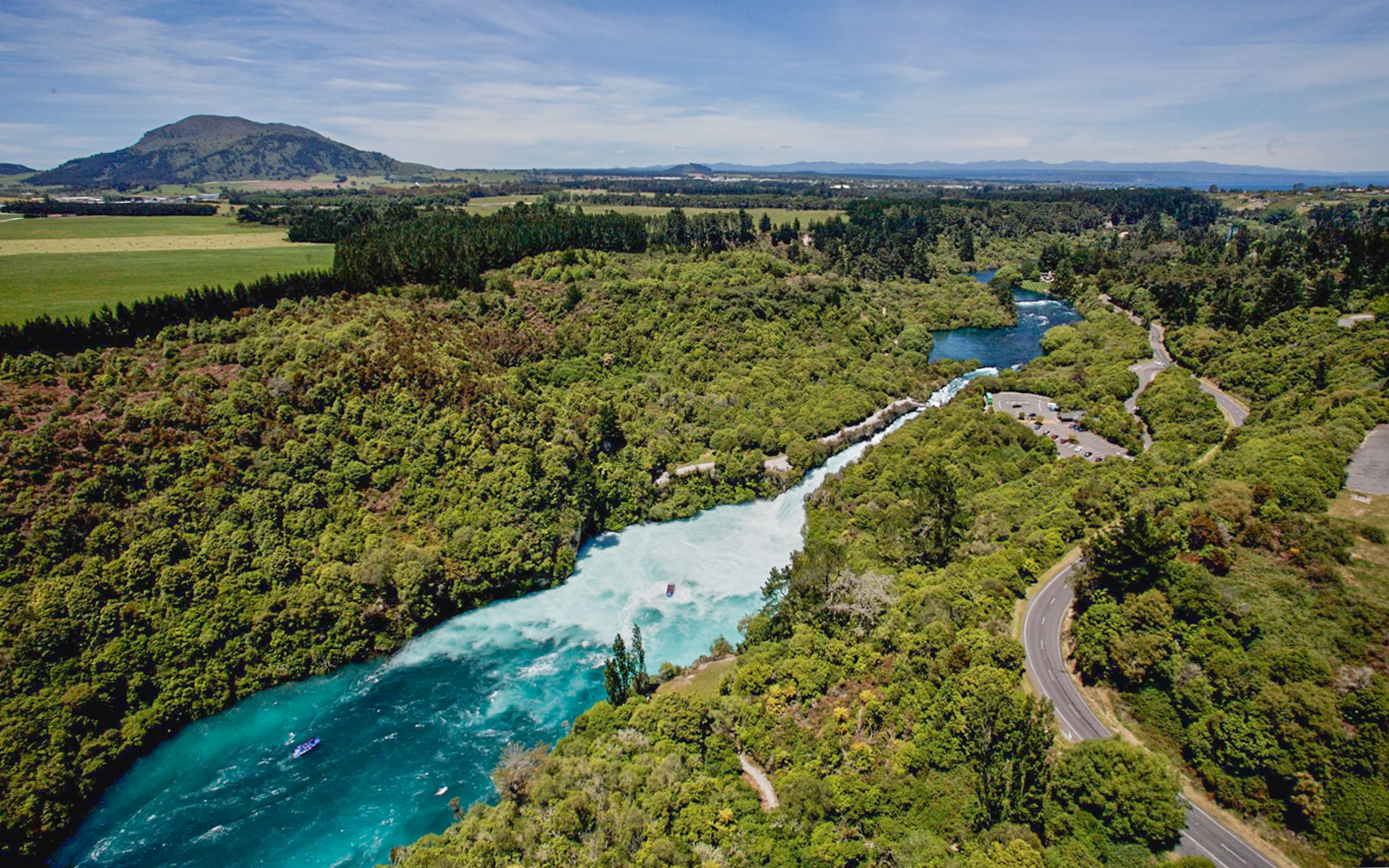 Aerial view of Huka Falls with a jet boat navigating the river in New Zealand.