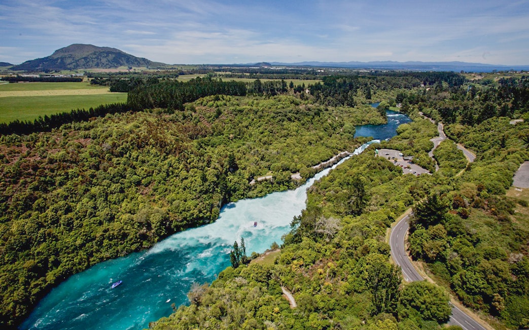 Aerial view of Huka Falls with a jet boat navigating the river in New Zealand.