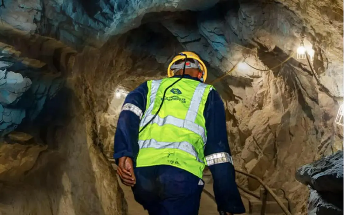 Worker in safety gear exploring Mererani Tanzanite Mine tunnel, Tanzania.